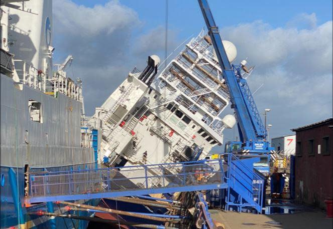 The research vessel Petrel leans against a dry dock in the Edinburgh suburb of Leith, in Scotland, March 22, 2023, after apparently being knocked over by strong winds. / Credit: Twitter / @Tomafc83