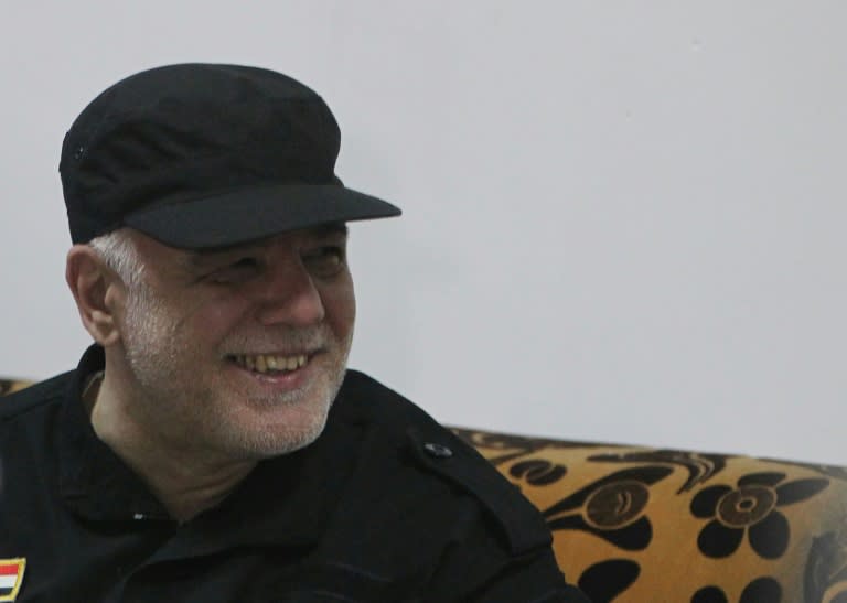 Iraqi Prime Minister Haider al-Abadi smiles during a meeting with military commanders in Mosul on July 9, 2017 after the government's announcement of the "liberation" of the embattled city