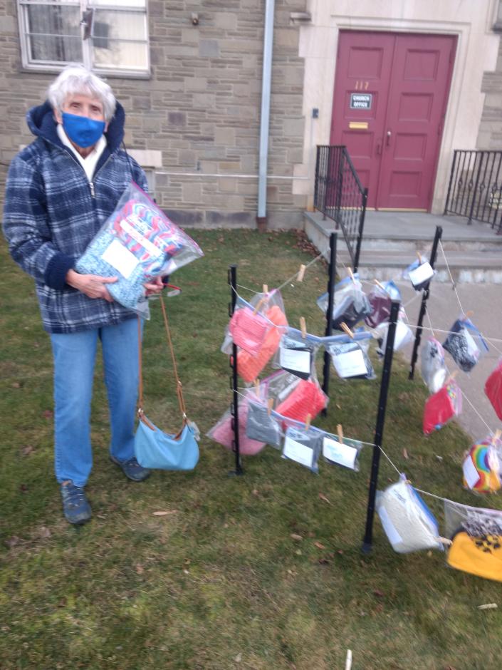 Diane Runion hangs a sash outside her church: Main Street Baptist Church in Binghamton #x002019;  s West Side.  Church members donate scarves, hats, and gloves to anyone who needs them.