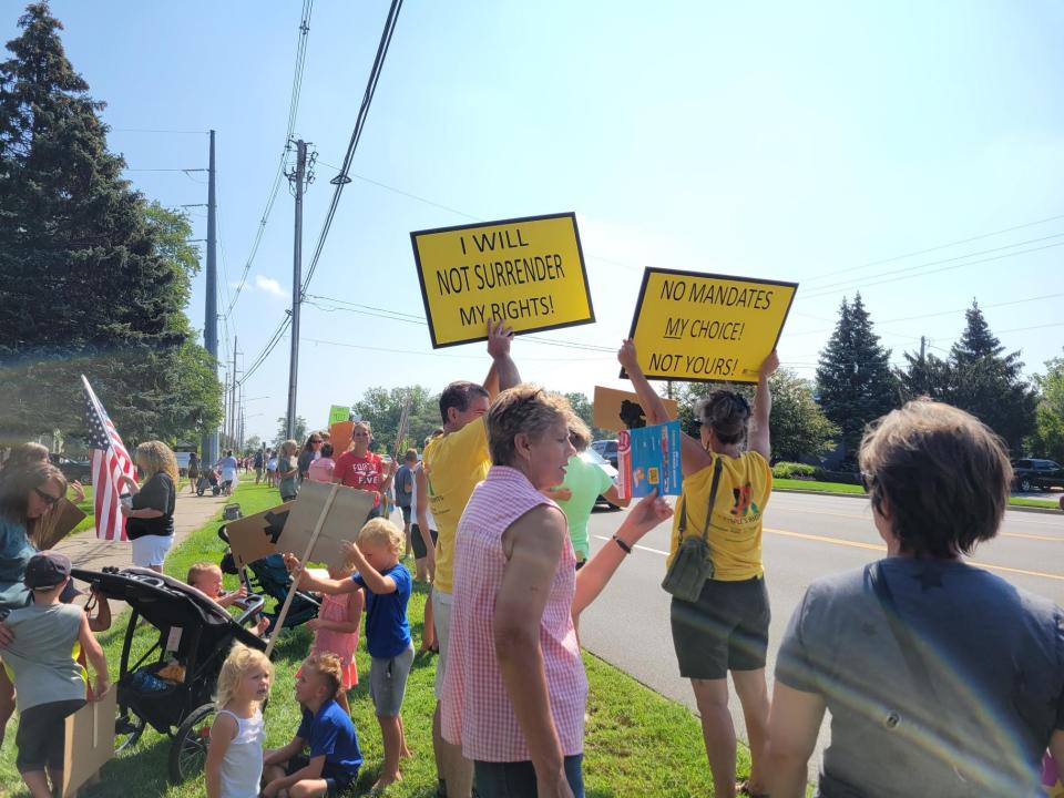 Protesters gather outside the Ottawa County Department of Public Health building to oppose a mask mandate in schools on Friday, Aug. 20, 2021, in Holland, Mich.