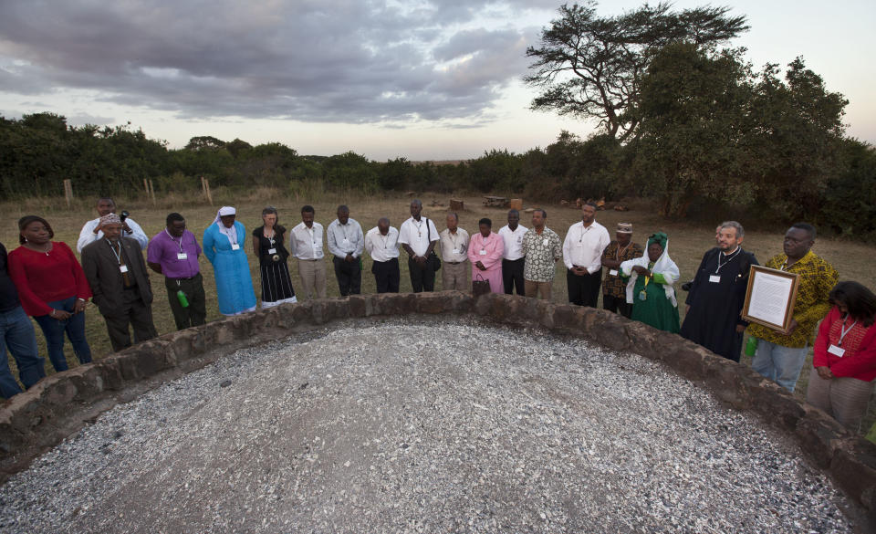 In this photo taken Thursday, Sept. 20, 2012, religious leaders of different faiths pray around a pile of charred elephant ivory at a site in Nairobi National Park where Kenyan officials burned hundreds of ivory tusks in 1989 to draw attention to the slaughter of elephants, in Nairobi, Kenya. Seeing a dire situation grow worse, the animal conservation group the World Wildlife Fund (WWF) enlisted religious leaders on Thursday, Sept. 20, 2012 in the fight to end the slaughter of Africa's elephants and rhinos by poachers, hoping that religion can help save some of the world's most majestic animals. (AP Photo/Ben Curtis)