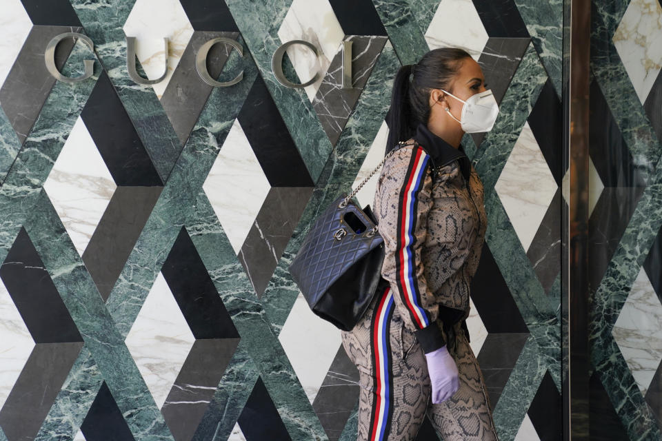 Delicia Cordon waits to pick up a purchase at Gucci on Rodeo Drive Tuesday, May 19, 2020, in Beverly Hills, Calif. The store is closed to the public, but offers curbside pickup. (AP Photo/Ashley Landis)