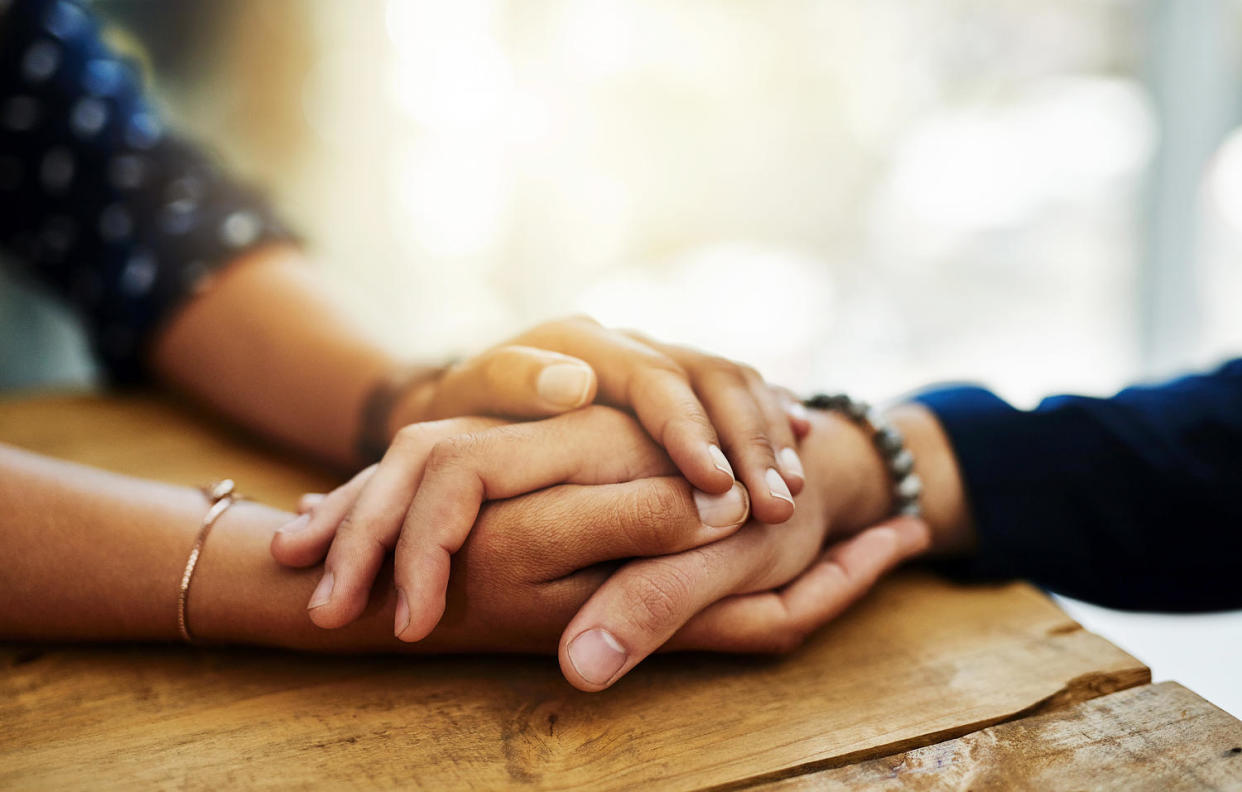 Closeup shot of two people holding hands in comfort (Getty Images)