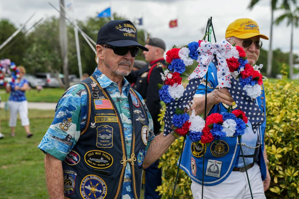 Former Base Commander and Veteran Bill Andrea holds a wreath along the lawn during a Memorial Day ceremony at the Palm Beach Memorial Park in Lantana on Monday May 29, 2023.