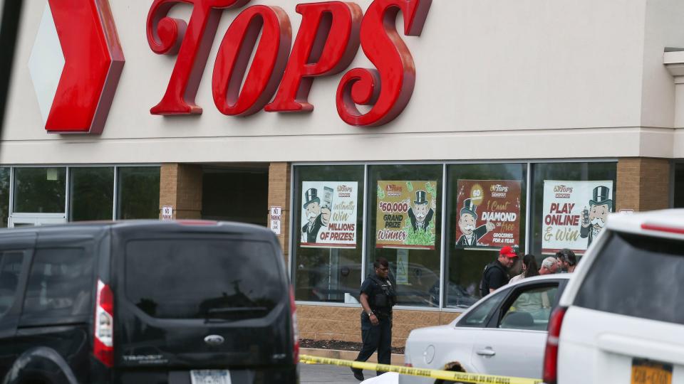 A crowd gathers as police investigate after a shooting at a supermarket on Saturday, May 14, 2022, in Buffalo, N.Y. Multiple people were shot  at the Tops Friendly Market.  Police have notified the public that the alleged shooter was in custody. (AP Photo/Joshua Bessex)