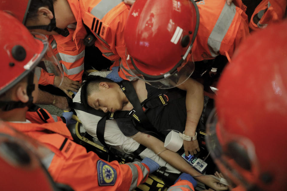 Medical staffs carry a detained man, who protesters claimed was a police officer from mainland China, during a demonstration at the Airport in Hong Kong, Tuesday, Aug. 13, 2019. Riot police clashed with pro-democracy protesters at Hong Kong's airport late Tuesday night, a chaotic end to a second day of demonstrations that caused mass flight cancellations at the Chinese city's busy transport hub. (AP Photo/Vincent Yu)