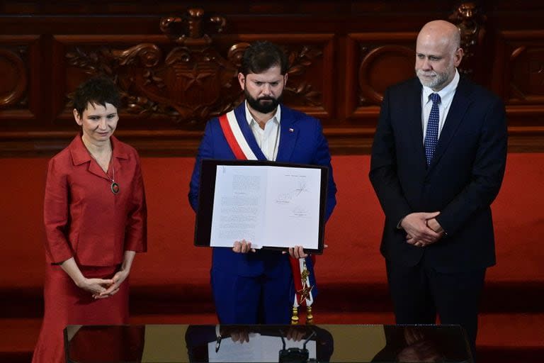 El Presidente de Chile, Gabriel Boric, junto a la Ministra Secretaria General de Gobierno, Carolina Toha, y el Ministerio Secretaría General de la Presidencia, Álvaro Elizalde, exhiben el decreto firmado que convoca a un plebiscito el 17 de diciembre de 2023, para votar la propuesta de nueva Constitución luego de entregado el texto final del proyecto, durante el acto de clausura del Proceso Constitucional en el Salón de Honor del Congreso Nacional en Santiago el 7 de noviembre de 2023.