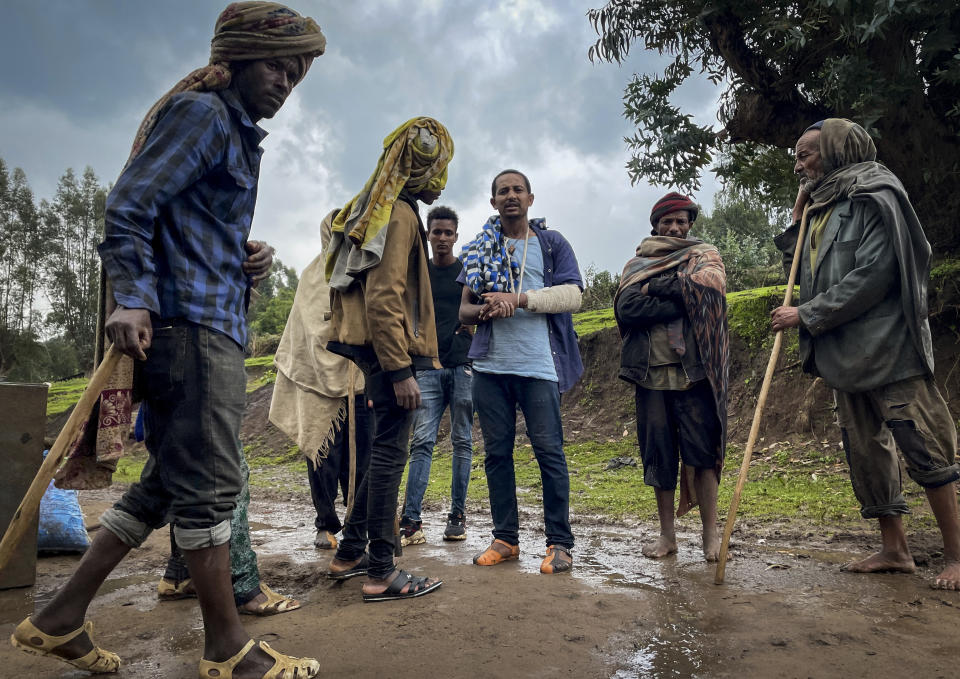 Men gather to speak to a militia fighter Kibret Bidere, with an injured arm, center, near the village of Chenna Teklehaymanot, in the Amhara region of northern Ethiopia Thursday, Sept. 9, 2021. At the scene of one of the deadliest battles of Ethiopia's 10-month Tigray conflict, witness accounts reflected the blurring line between combatant and civilian after the federal government urged all capable citizens to stop Tigray forces "once and for all." (AP Photo)