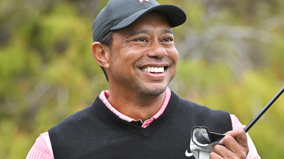 Tiger Woods smiles as he prepares to play a shot.