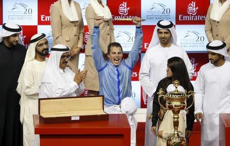 William Buick (C), who competed with Prince Bishop, celebrates after winning the ninth and final race of the Dubai World Cup at the Meydan Racecourse in Dubai March 28, 2015. REUTERS/Ahmed Jadallah