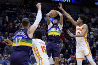 New Orleans Pelicans forward Brandon Ingram (14) shoots next to Atlanta Hawks forward De'Andre Hunter (12) during the first half of an NBA basketball game in New Orleans, Tuesday, Feb. 7, 2023. (AP Photo/Matthew Hinton)