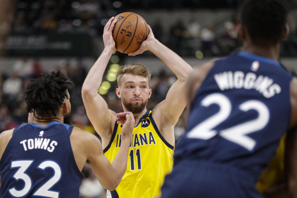 Indiana Pacers forward Domantas Sabonis (11) looks to pass between Minnesota Timberwolves center Karl-Anthony Towns (32) and forward Andrew Wiggins (22) during the second half of an NBA basketball game in Indianapolis, Friday, Jan. 17, 2020. The Pacers won 116-114. (AP Photo/Michael Conroy)