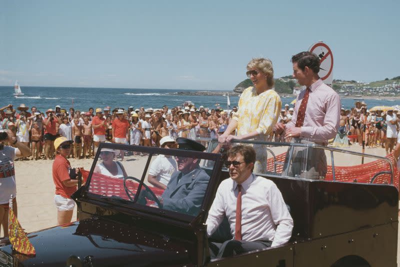 <p> Wearing a bright yellow floral printed sundress with Prince Charles in a jeep on a visit to a beach in New South Wales, Australia. </p>