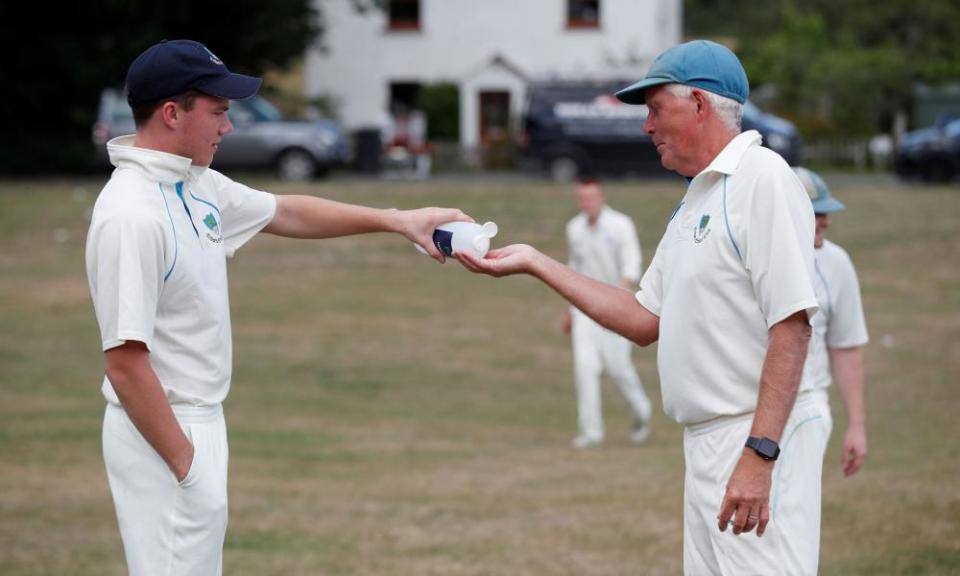 The players share hand sanitiser at Tilford Cricket Club.