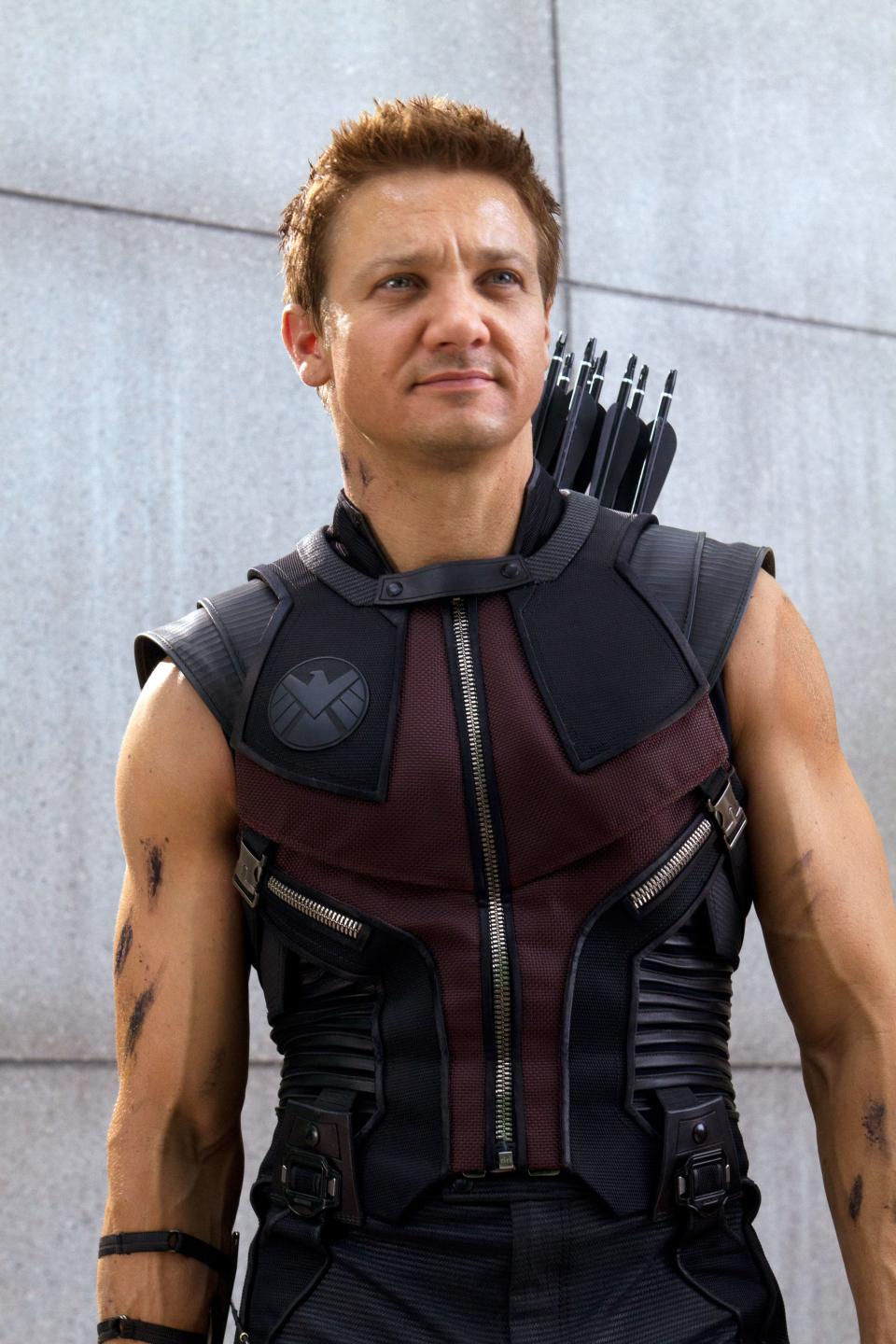 Jeremy Renner dressed as Hawkeye, wearing a tactical, sleeveless uniform with archery gear on his back