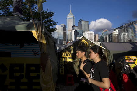 Pro-democracy protesters walk past a tent setting up by protesters during a demonstration outside Legislative Council in Hong Kong, China June 17, 2015. REUTERS/Tyrone Siu