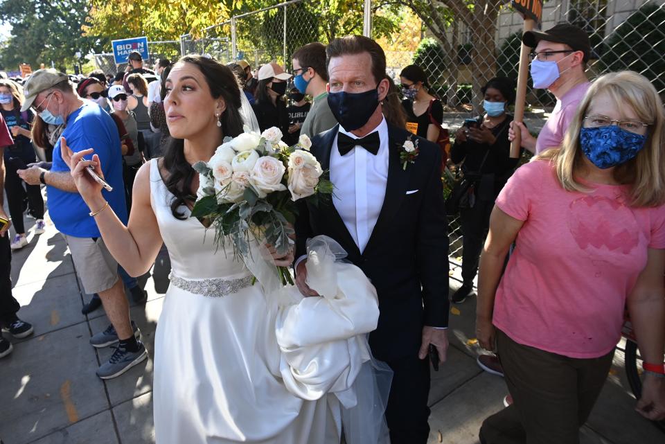 <p>Newlyweds walk through Black Lives Matter Plaza as people celebrate across from the White House</p>AFP via Getty Images