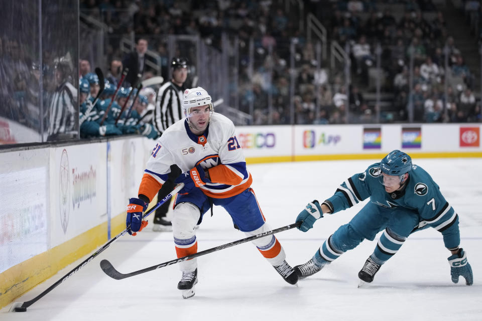 New York Islanders center Kyle Palmieri, left, moves the puck while defended by San Jose Sharks center Nico Sturm during the first period of an NHL hockey game in San Jose, Calif., Saturday, March 18, 2023. (AP Photo/Godofredo A. Vásquez)