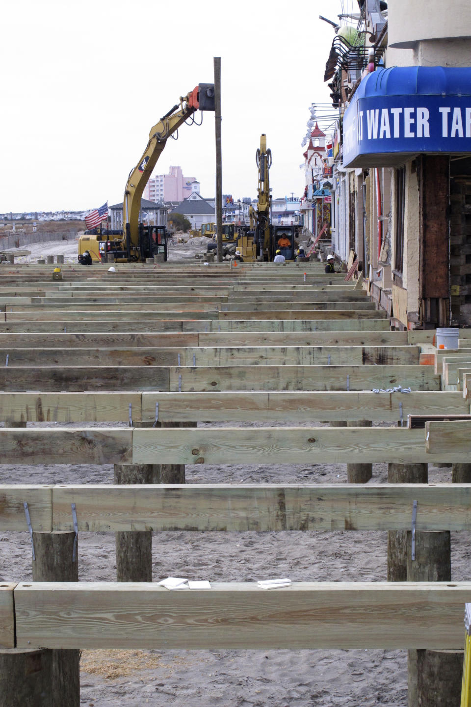 Workers replace part of the boardwalk in Ocean City N.J. on Dec. 6, 2017. On Feb. 23, 2024, New Jersey selected 18 Jersey Shore towns to split $100 million in funds to repair or rebuild their boardwalks. (AP Photo/Wayne Parry)