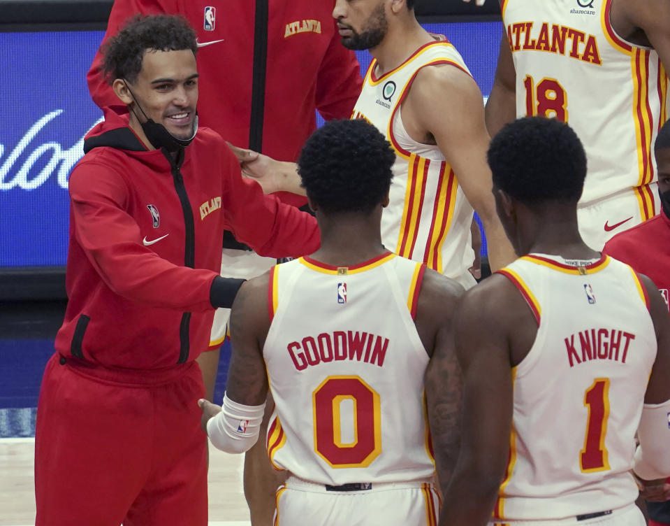 Atlanta Hawks guard Trae Young, left, celebrates a win with teammates Brandon Goodwin (0) and Nathan Knight (1) at the end of an NBA basketball game against the Orlando Magic Thursday, May 13, 2021 in Atlanta. (AP Photo/Tami Chappel)