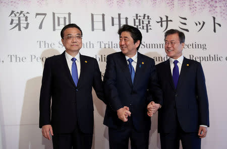 Chinese Premier Li Keqiang, Japanese Prime Minister Shinzo Abe and South Korean President Moon Jae-in pose for photographers prior to their summit in Tokyo, Wednesday, May 9, 2018. Eugene Hoshiko/Pool via Reuters