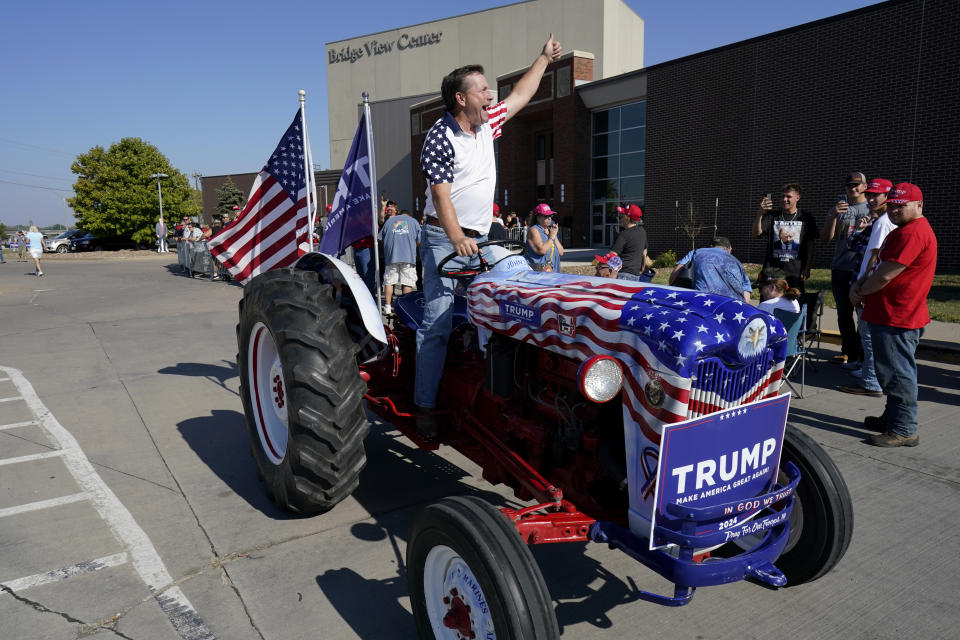 Gary Leffler drives his tractor past supporters before the arrival of former President Donald Trump at a rally, Sunday, Oct. 1, 2023, in Ottumwa, Iowa. (AP Photo/Charlie Neibergall)