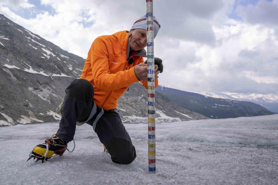 FILE - ETH (Swiss Federal Institute of Technology) glaciologist and head of the Swiss measurement network 'Glamos', Matthias Huss, checks the thickness of the Rhone Glacier near Goms, Switzerland, Friday, June 16, 2023. A top glacier watcher has warned that a warm early summer and a heat wave could have caused severe glacier melt across Switzerland, threatening to make 2023 the second-worst year for ice loss after a record thaw last year. (AP Photo/Matthias Schrader, FIle)