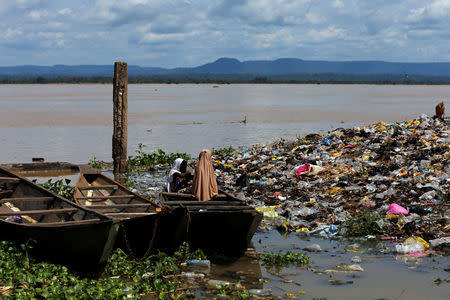 Girls are seen sitting in a canoe amid rubbish after the Benue river burst its banks in Lokoja city, Kogi State, Nigeria September 17, 2018. REUTERS/Afolabi Sotunde