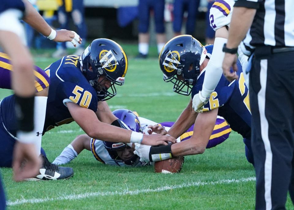 Jack Iott (50) and Jake Iott (right) pounce on a fumble for Whiteford last season. The twins both have been named to the Michigan High School Football Coaches Association All-State team.