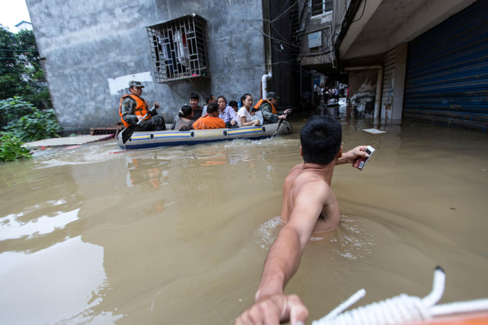 <p>Rescuers row as they transfer residents with a boat at a flooded area in Guilin, Guangxi province, China, July 2, 2017. (Photo: Stringer/Reuters) </p>
