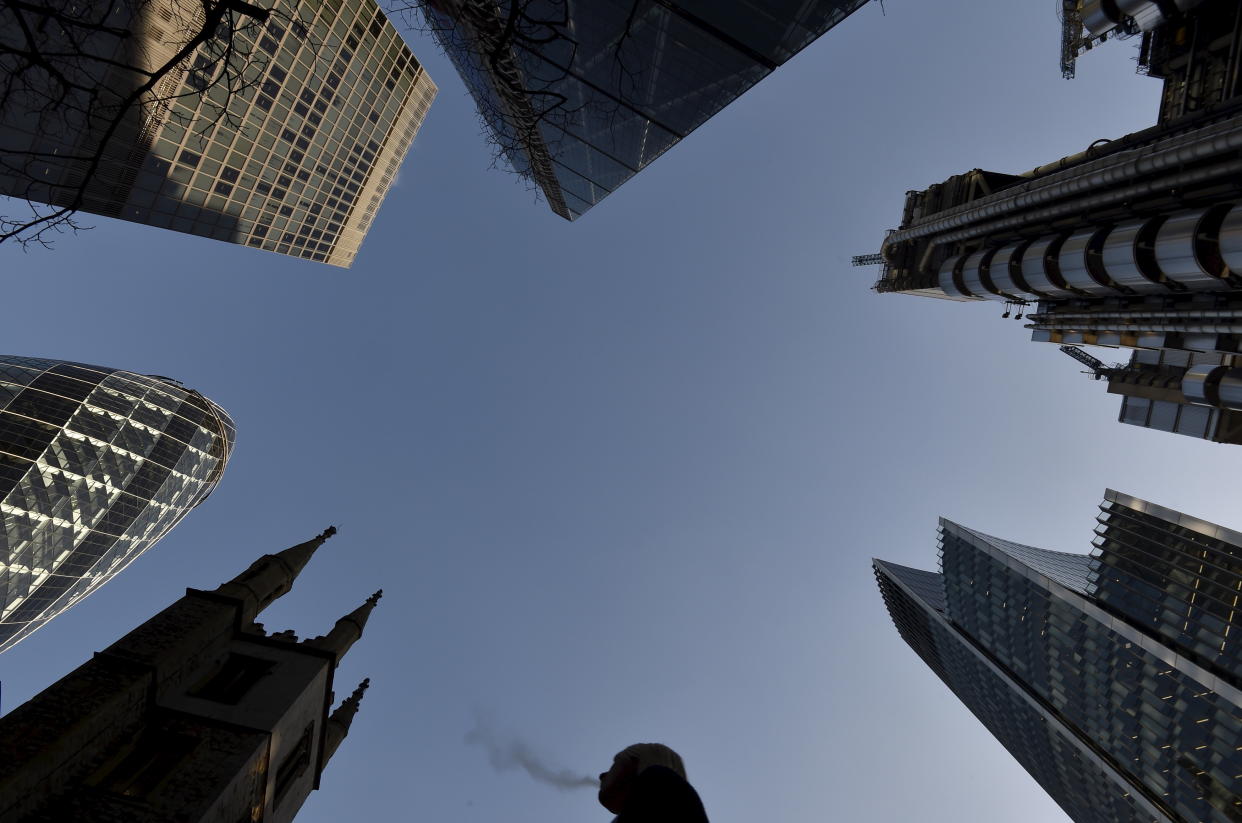 A city worker walks through the City of London with St. Andrew Undershaft church 