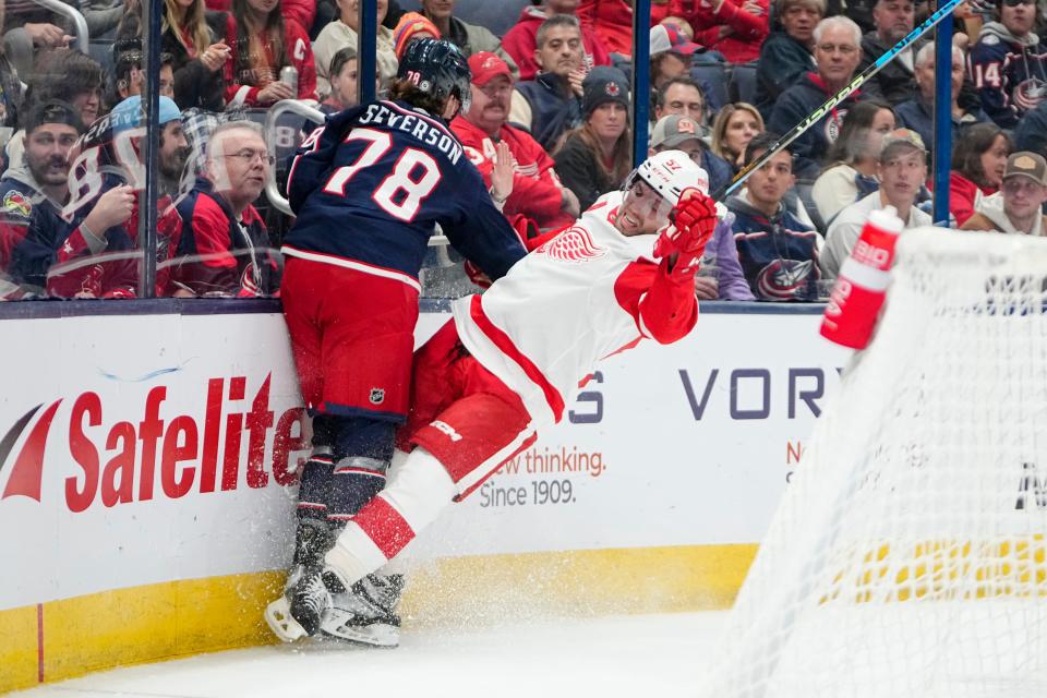Oct 16, 2023; Columbus, Ohio, USA; Columbus Blue Jackets defenseman Damon Severson (78) hits Detroit Red Wings left wing David Perron (57) during the second period of the NHL hockey game at Nationwide Arena.