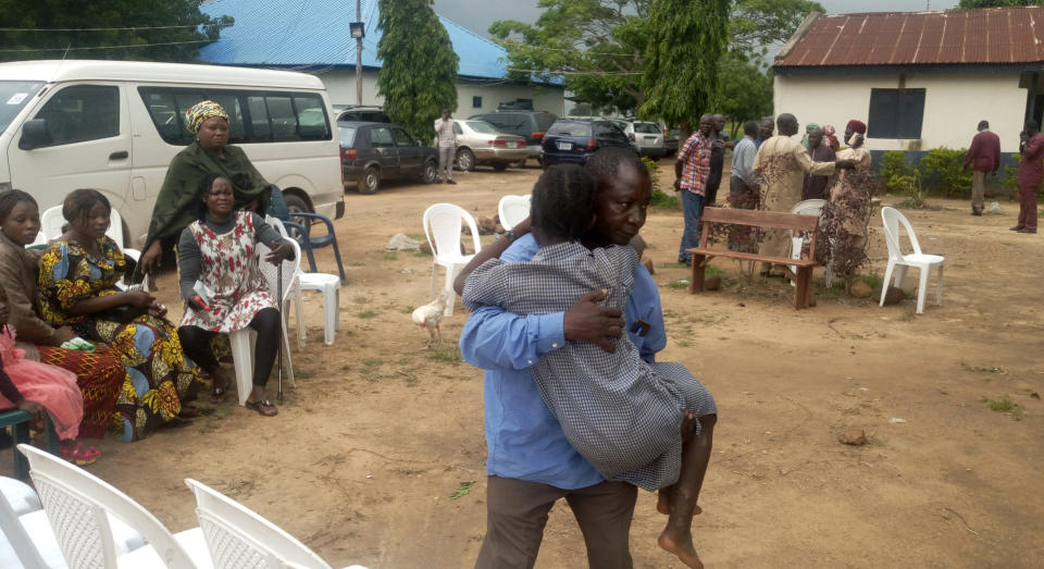 Parents are reunited with released students of the Bethel Baptist High School in Damishi, Nigeria, on Sunday, July 25, 2021. Armed kidnappers in Nigeria have released 28 of the more than 120 students who were abducted at the beginning of July from the Bethel Baptist High School in the northern town of Damishi. Church officials handed those children over to their parents at the school on Sunday. (AP Photo)