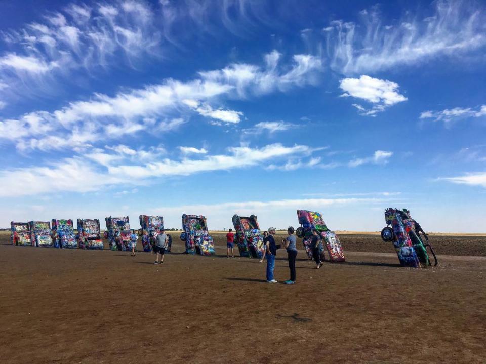 Cadillac Ranch features 10 Cadillacs buried nose first in a wheat field alongside Interstate 40 on the west edge of Amarillo. Visitors spray paint the installation.