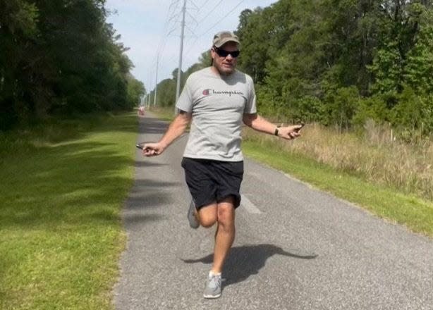 Daryl Rosenberger, shown on the trail between Baldwin and Jacksonville, has crossed the United States by skipping rope and walking. He's doing it to honor his son Drew who committed suicide in 2020 at the age of 30. Rosenberger is marking his journey's completion in Jacksonville Beach on Saturday.