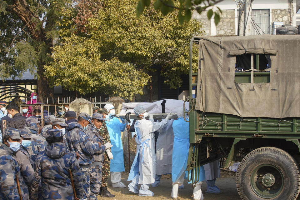 Medical personnel load the body of a victim onto a truck to be transported to Kathmandu, in Pokhara, Nepal, Tuesday, Jan 17, 2023. Nepalese authorities on Tuesday began returning to families the bodies of victims of a flight that crashed Sunday, and said they were sending the aircraft's data recorder to France for analysis as they try to determine what caused the country's deadliest plane accident in 30 years. (AP Photo/Yunish Gurung)