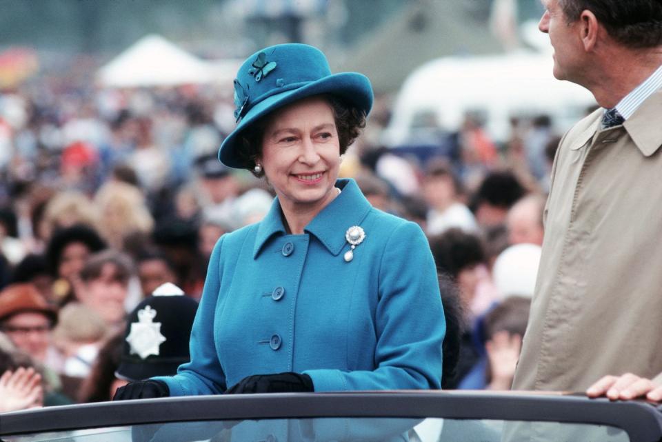 <p>Queen Elizabeth II and Prince Philip attend an event in Hyde Park with the queen sporting a turquoise-hued suit and matching hat—topped off with an oversized pearl pin. </p>