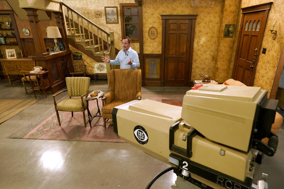 James Comisar responds to questions during an interview as he stands amongst the set of the television show "All in the Family", Thursday, April 27, 2023, in Irving, Texas. A dizzying number of props, sets, and costumes from television shows beloved by generations of viewers will be sold at auction next month. The collection James Comisar has spent over 30 years amassing includes "The Tonight Show" set Johnny Carson gave him after retiring, the timeworn living room from "All in the Family," and the bar where Sam Malone served customers on Cheers. (AP Photo/Tony Gutierrez)