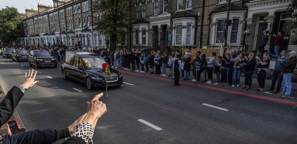 A person throws a flower towards Britain's Queen Elizabeth's coffin as it is transported on the day of her state funeral and burial.<span class="copyright">Carlos Barria—Reuters</span>