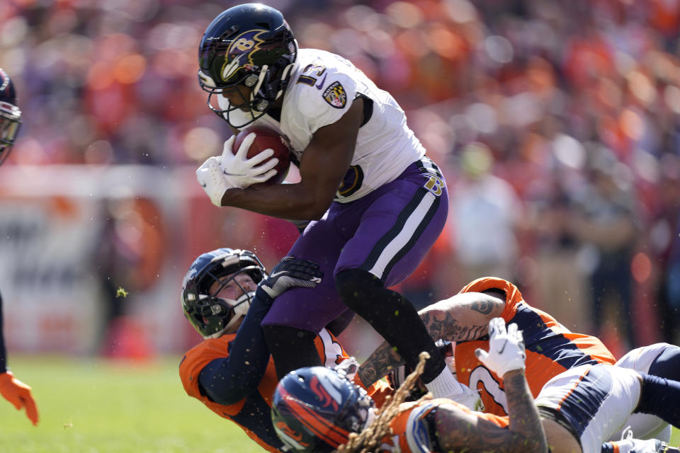 Baltimore Ravens wide receiver Devin Duvernay (13) it tackled against the Denver Broncos during the first half of an NFL football game, Sunday, Oct. 3, 2021, in Denver. (AP Photo/David Zalubowski)