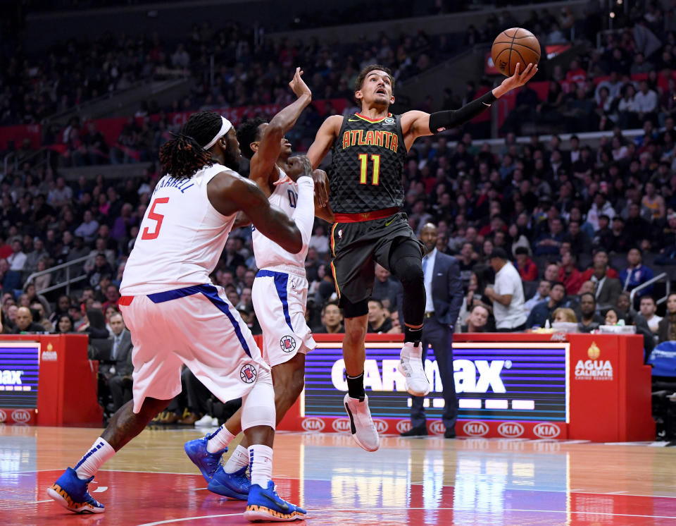 LOS ANGELES, CALIFORNIA - JANUARY 28:  Trae Young #11 of the Atlanta Hawks scores on a layup past Shai Gilgeous-Alexander #2 and Montrezl Harrell #5 of the LA Clippers during the first half at Staples Center on January 28, 2019 in Los Angeles, California. (Photo by Harry How/Getty Images)