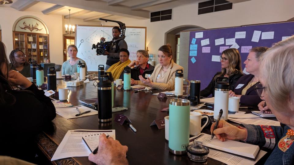 A group of people speaking around a table