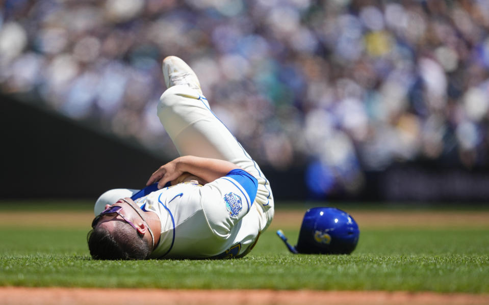 Seattle Mariners' Ty France falls on the ground after colliding with Tampa Bay Rays third baseman Isaac Paredes while running to third base on a single from Teoscar Hernandez during the third inning of a baseball game, Sunday, July 2, 2023, in Seattle. (AP Photo/Lindsey Wasson)