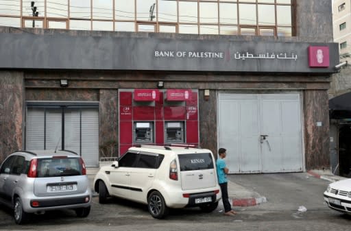 A Palestinian man stands in front of a closed bank during a general strike in support of an Israeli-Arab protest against the Jewish Nation-State Law in Gaza City on October 1, 2018