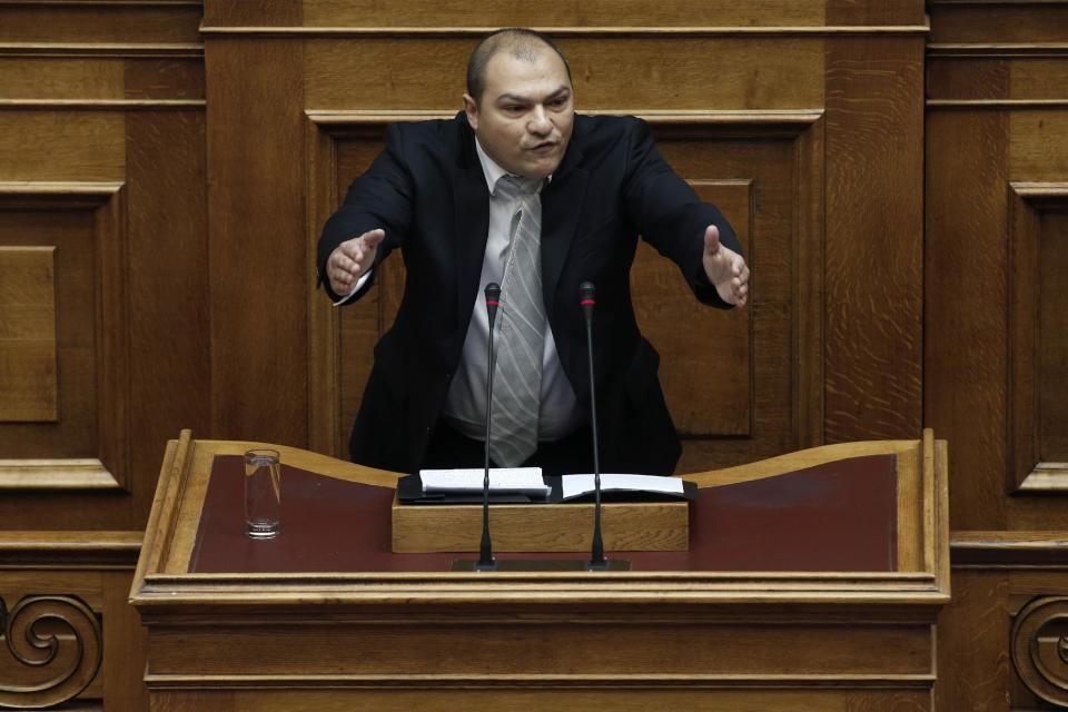 Golden Dawn lawmaker Georgios Germenis, one of five party lawmakers jailed pending trial for allegedly running a criminal organization, speaks during a parliament session in Athens, on Wednesday, May 7, 2014. Two jailed Greek lawmakers granted special prison leave have appeared in Parliament to defend themselves against charges linked with a judicial crackdown on the Nazi-inspired Golden Dawn party.(AP Photo/Petros Giannakouris)