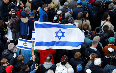 An Israeli flag is held during a demonstration in front of a Jewish synagogue, to denounce an anti-Semitic attack on a young man wearing a kippa in the capital earlier this month, in Berlin, Germany, April 25, 2018. REUTERS/Fabrizio Bensch