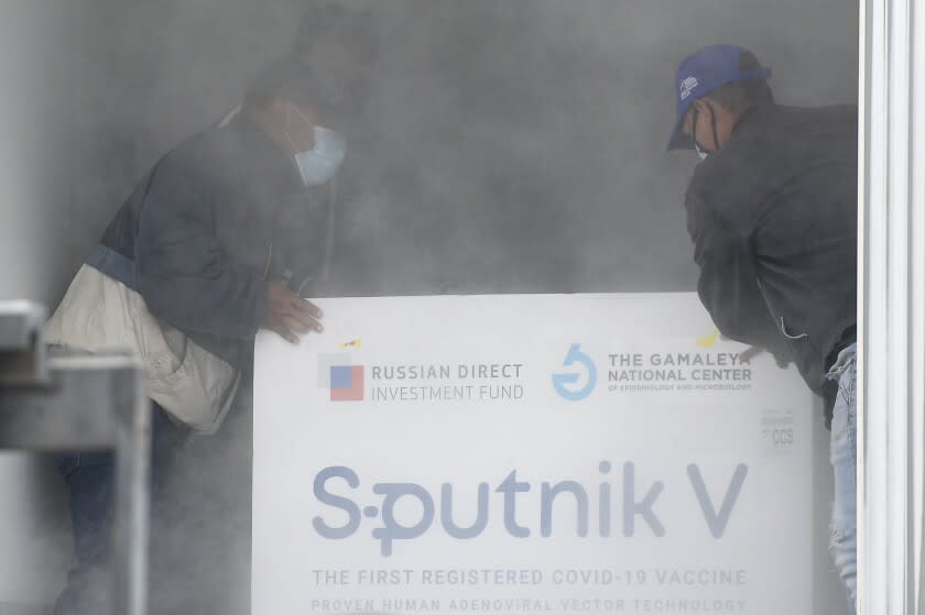 FILE - Workers place a box containing doses of the Russian COVID-19 vaccine Sputnik V into a refrigerated container after unloading it from a plane, at the Simon Bolivar International Airport in Maiquetia, Venezuela, Feb. 13, 2021. On Monday, the U.S. will implement a new air travel policy to allow in foreign citizens who have completed a course of a vaccine approved by the Food and Drug Administration or the World Health Organization. That leaves people in Mexico, Hungary, Russia and elsewhere who received the non-approved Russian Sputnik V vaccine or the China-produced CanSino vaccine ineligible to board U.S.-bound flights. (AP Photo/Matias Delacroix, File)