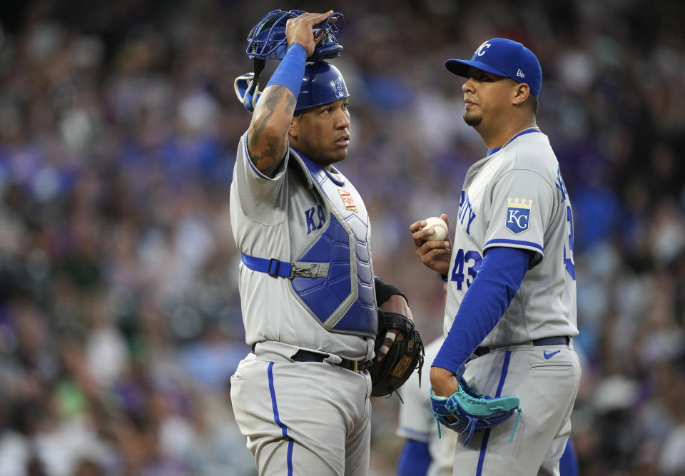 Kansas City Royals catcher Salvador Perez, left, talks with starting pitcher Carlos Hernandez, who had given up an RBI double to Colorado Rockies' Brendan Rodgers during the fifth inning of a baseball game Saturday, May 14, 2022, in Denver. (AP Photo/David Zalubowski)