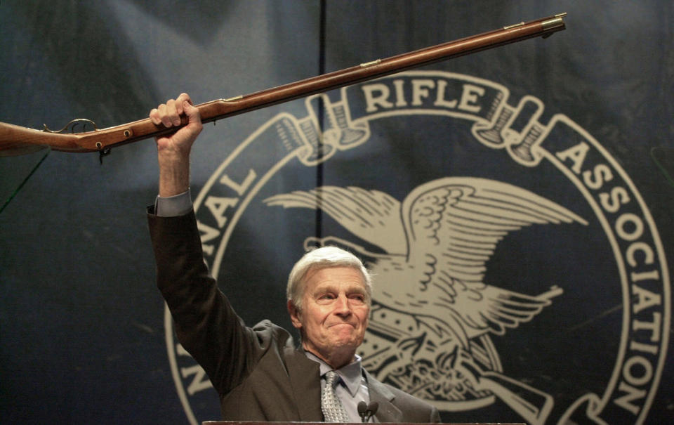 FILE - In this May 20, 2000, file photo, NRA president Charlton Heston holds up a musket as he tells the 5000 plus members attending the 129th Annual Meeting & Exhibit in Charlotte, N.C., that they can have his gun when they pry it "from my cold dead hands, " The ending to his speech drew a standing ovation. (AP Photo/Ric Feld, File)