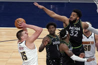 Denver Nuggets' Nikola Jokic (15) shoots as Minnesota Timberwolves' Karl-Anthony Towns (32) defends during the first half of an NBA basketball game Thursday, May 13, 2021, in Minneapolis. (AP Photo/Jim Mone)